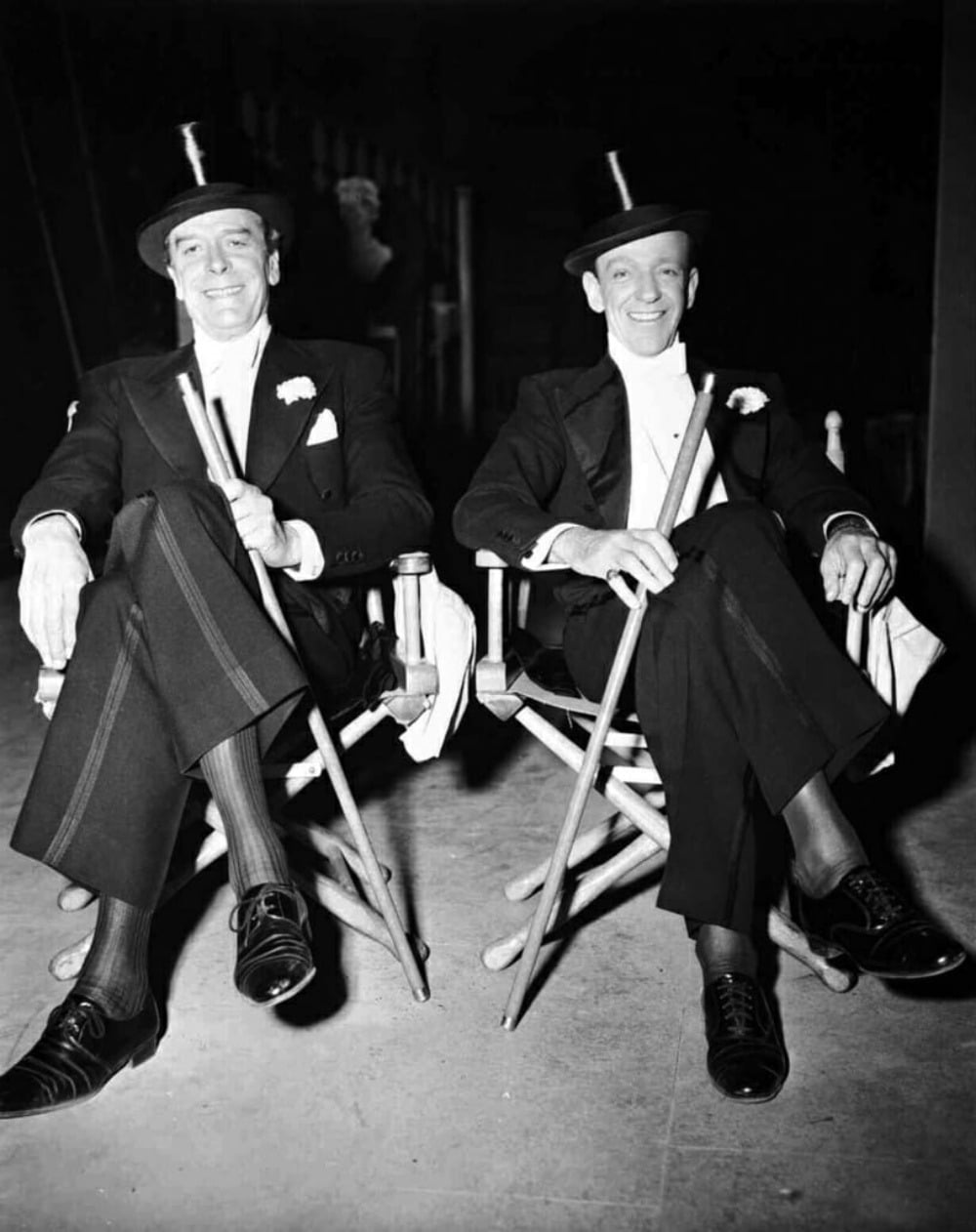 Trái: Jack Buchanan với tất lụa có gân và giày derby. Phải: Fred Astaire với giày oxfords captoe buộc chéo. Cả hai cùng mang vớ cao để không lộ bắp chân khi ngồi. Trên đầu đội nón top hat, tay cầm gậy. 